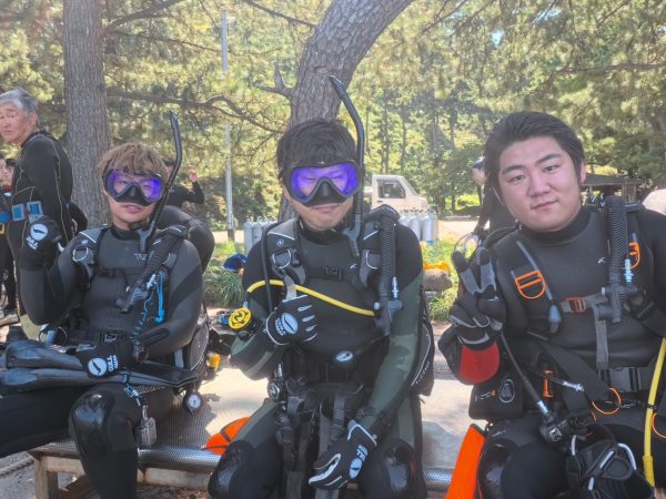 ダイビング男子3人が集合写真を撮っている様子