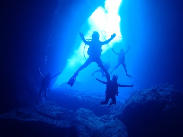 ダイバーが海の中にある洞窟で潜っている様子