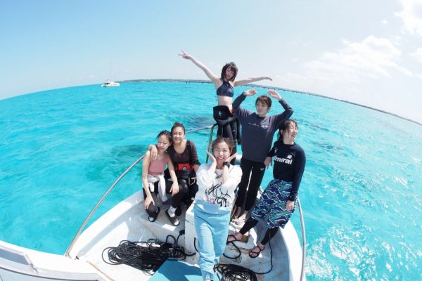 船の上で集合写真を撮る複数の女性。